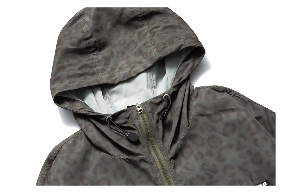 Flat-lay view of a charcoal animal-pattern hooded jacket, showing the hood, pale lining, zipper, and drawcords.