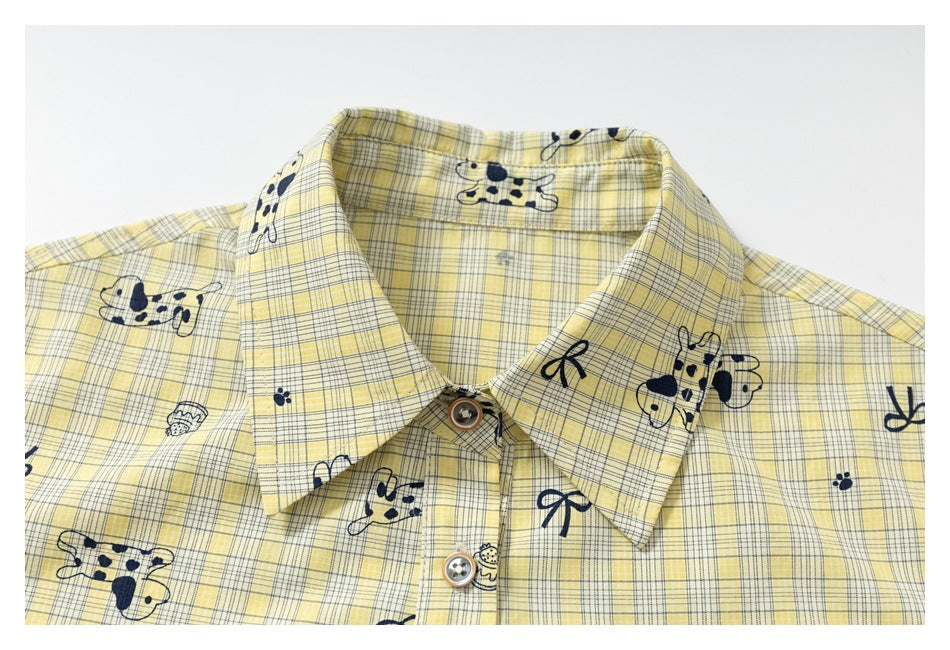 Close-up of the pointed collar and buttons on a yellow plaid shirt with navy animal and bow prints.