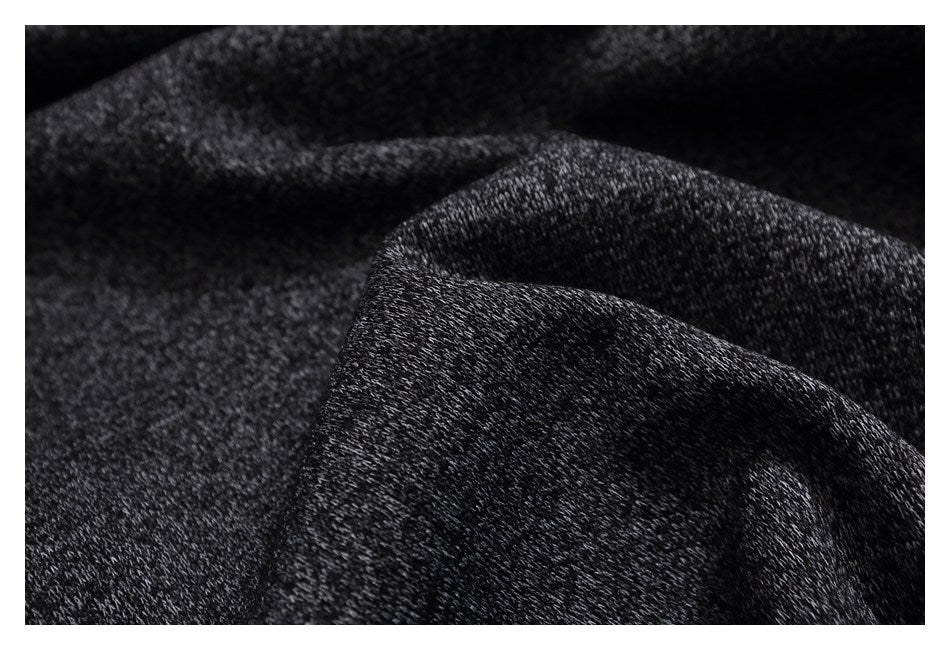 Macro view of the dark heather-gray garment's textured fabric gathered into folds.
