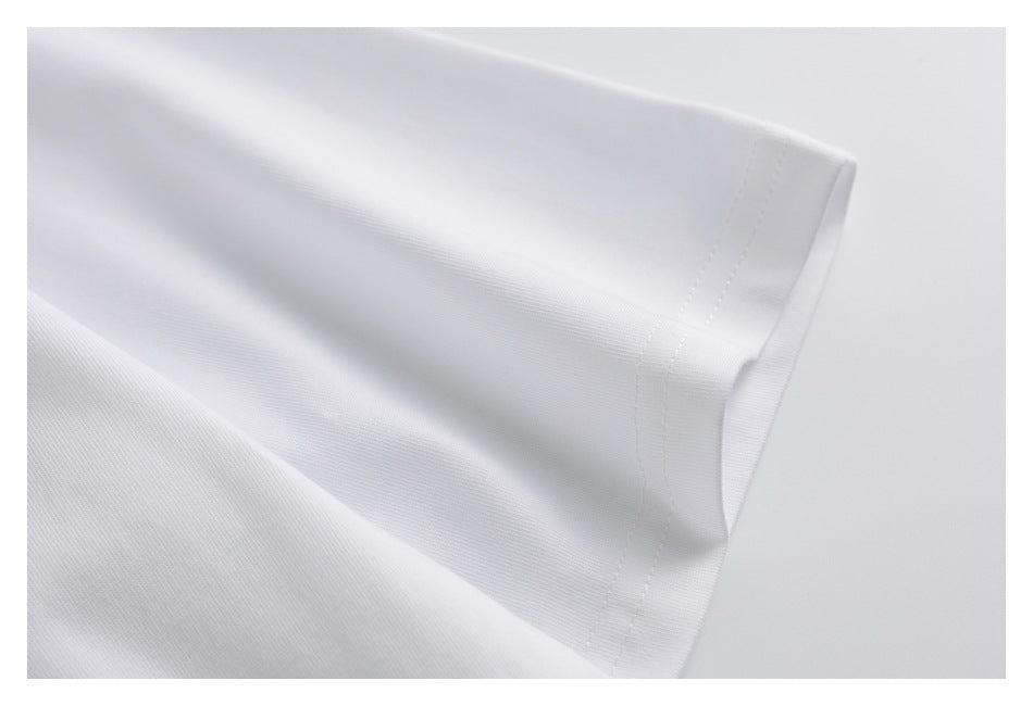 Close-up of a white garment edge with parallel stitching and a folded hem.