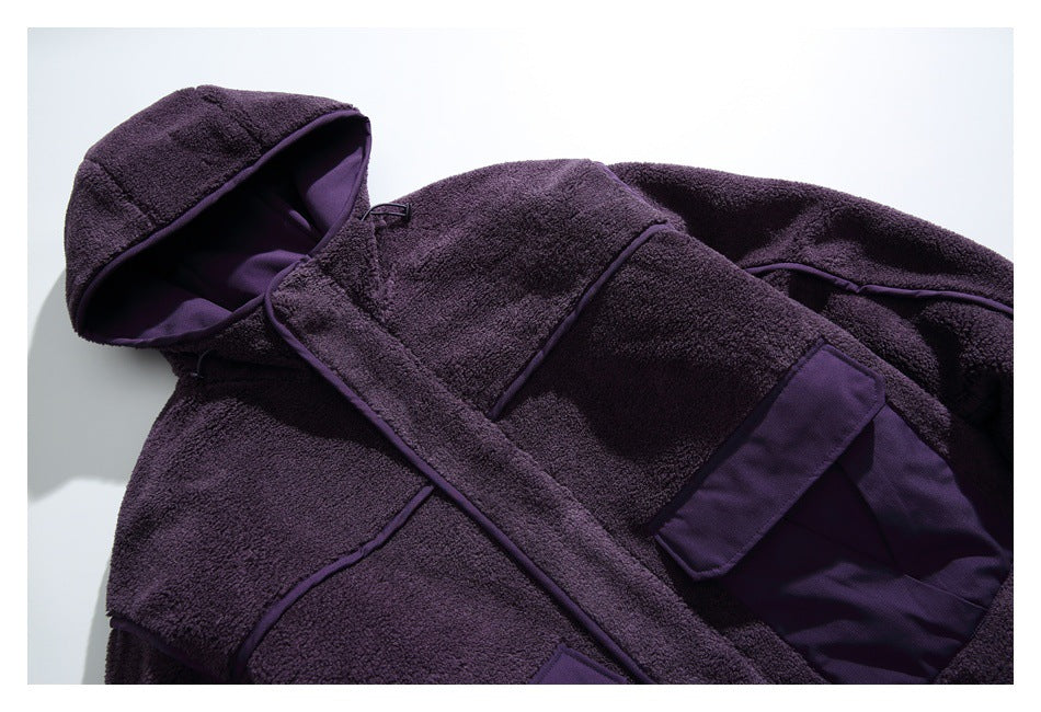 Close view of a dark purple fleece jacket front with a lined hood, contrasting trim, and flap pockets.