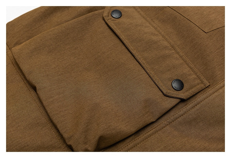 Close-up of a brown jacket front with a flap, stitched seams, and two black buttons.
