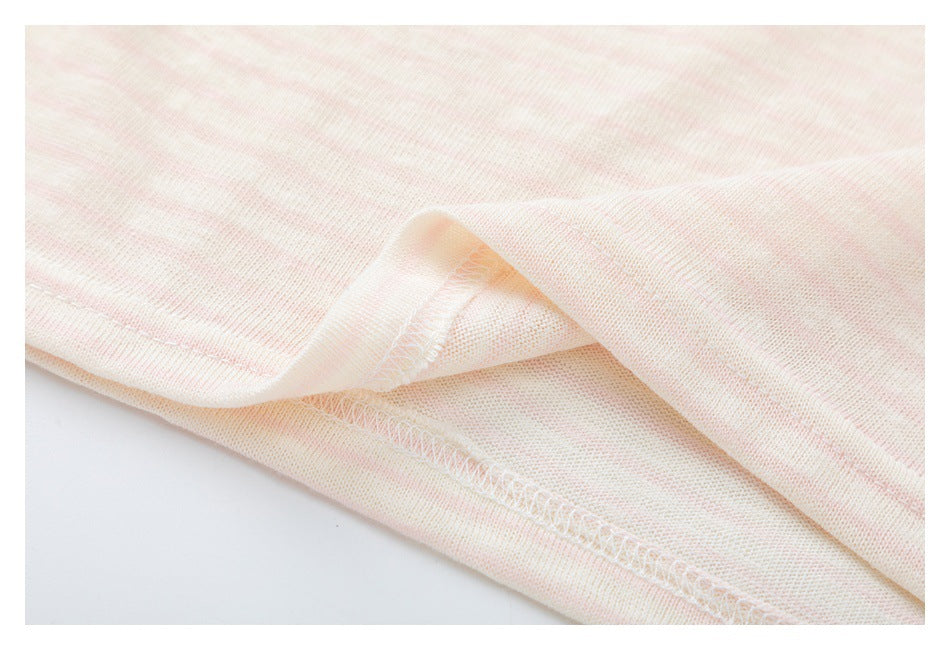 Close-up of a pale pink and cream striped garment hem with visible overlock stitching.