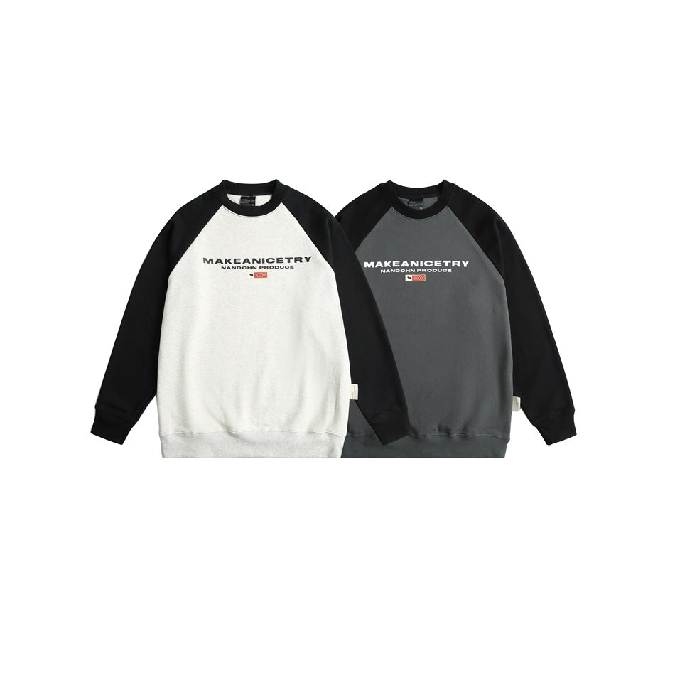 Two raglan crewneck sweatshirts shown side by side: one with a white body and one charcoal gray, both with black sleeves and
