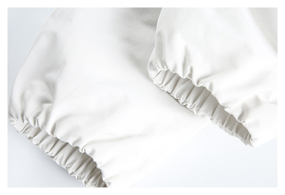 Close-up of elasticated cuffs on a white garment.