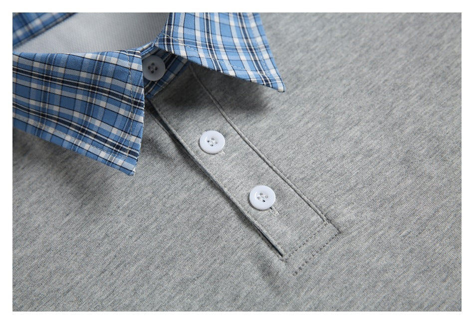 Close-up of a gray shirt with a blue plaid collar, gray button placket, and white buttons.