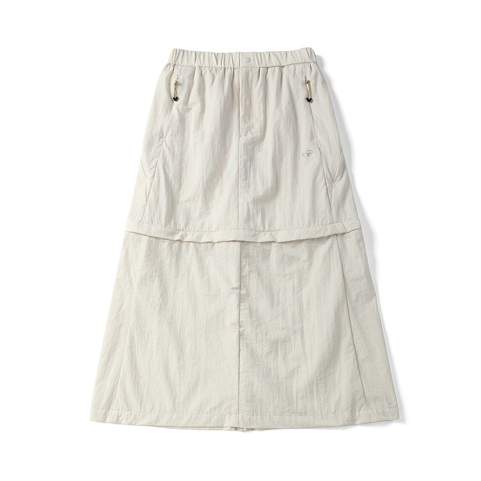 Off-white midi skirt flat lay with elastic waist, snap button, cord-pull zip pockets and a two-tier seam