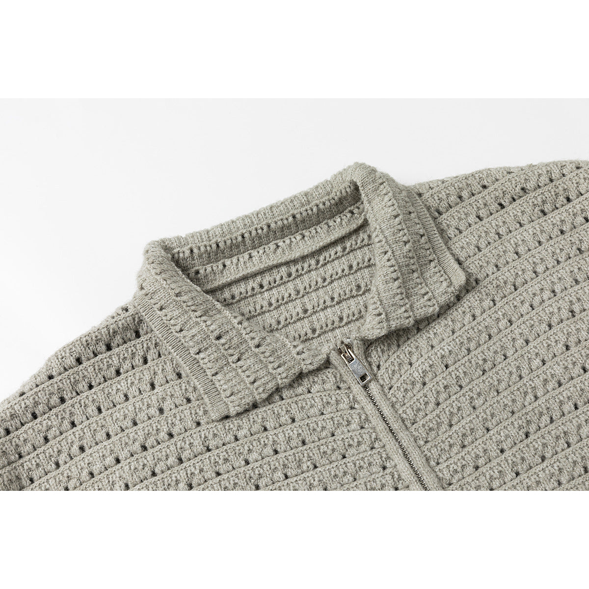 Close-up of a light gray textured knit cardigan collar and front zipper.