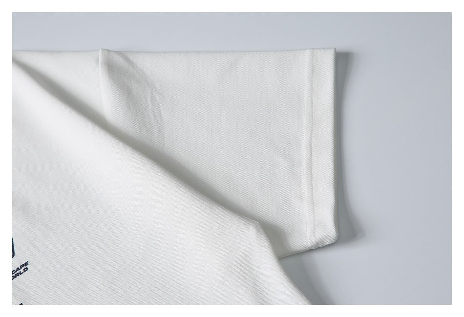 Close-up of a white garment sleeve and seam, with a small portion of navy print visible at the edge.