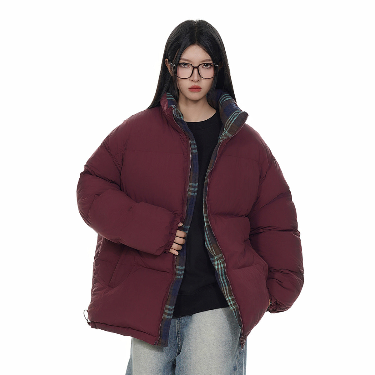 Model wearing a burgundy puffer jacket with plaid lining visible at the open collar and front, front view.