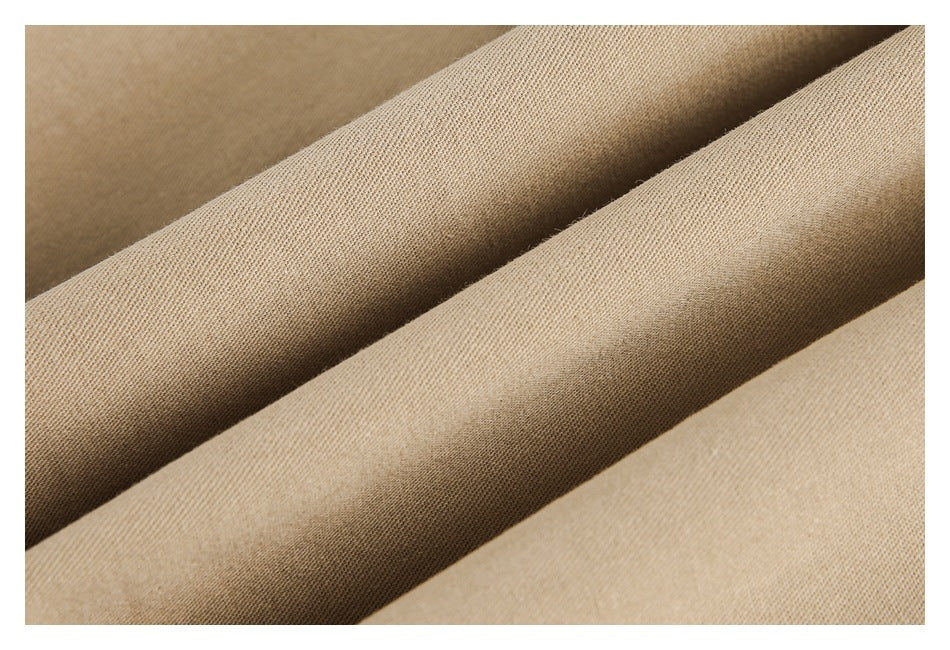 Close-up of beige fabric draped in folds, showing its fine woven surface.