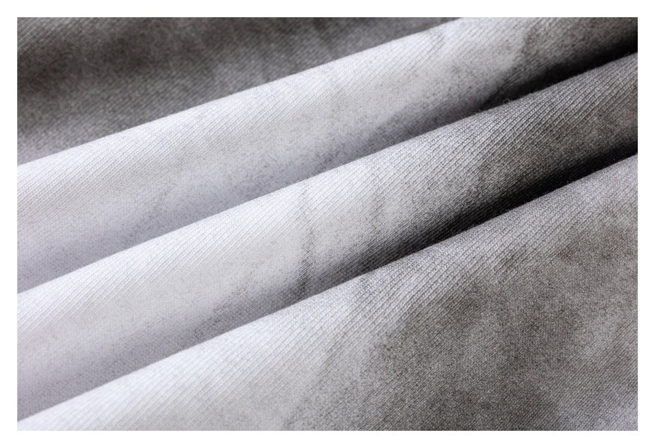 Close-up of folded knit fabric in light gray, white, and dark gray, showing its ribbed texture.