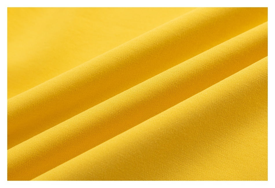 Macro view of yellow fabric draped in folds, showing its surface texture.