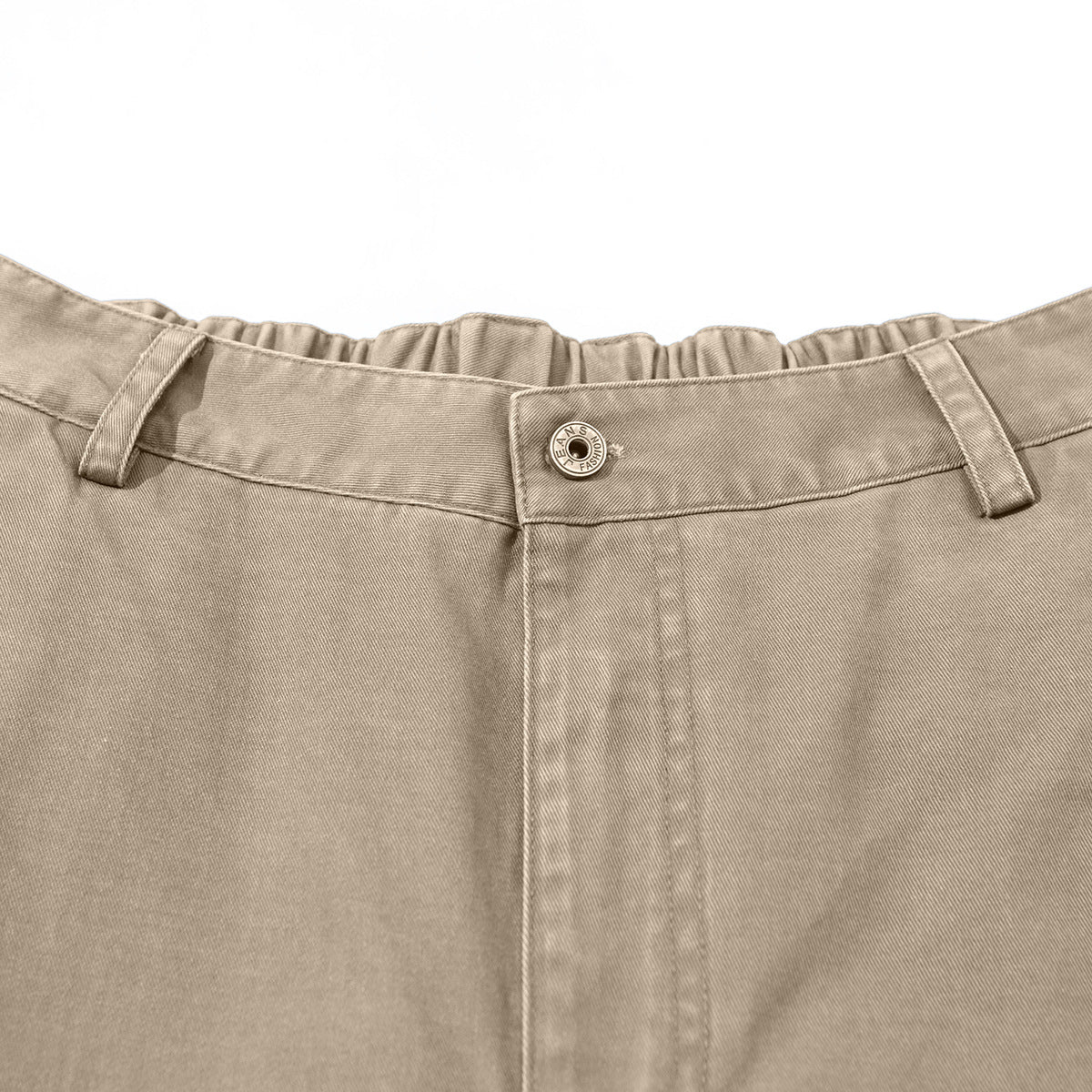 Close-up of taupe trousers showing the buttoned waistband, belt loops, and front fly.