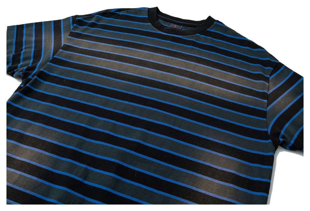 Angled flat view of a short-sleeve crew-neck T-shirt with black, charcoal, and bright blue horizontal stripes.