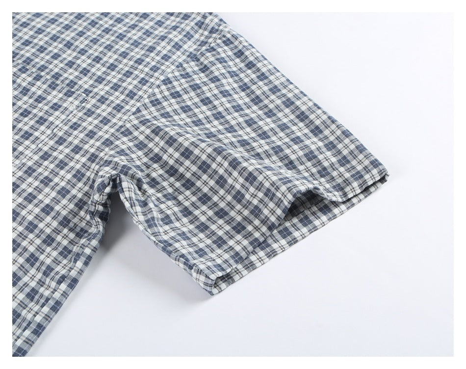 Close-up of a short sleeve on a blue, gray, and white plaid shirt.