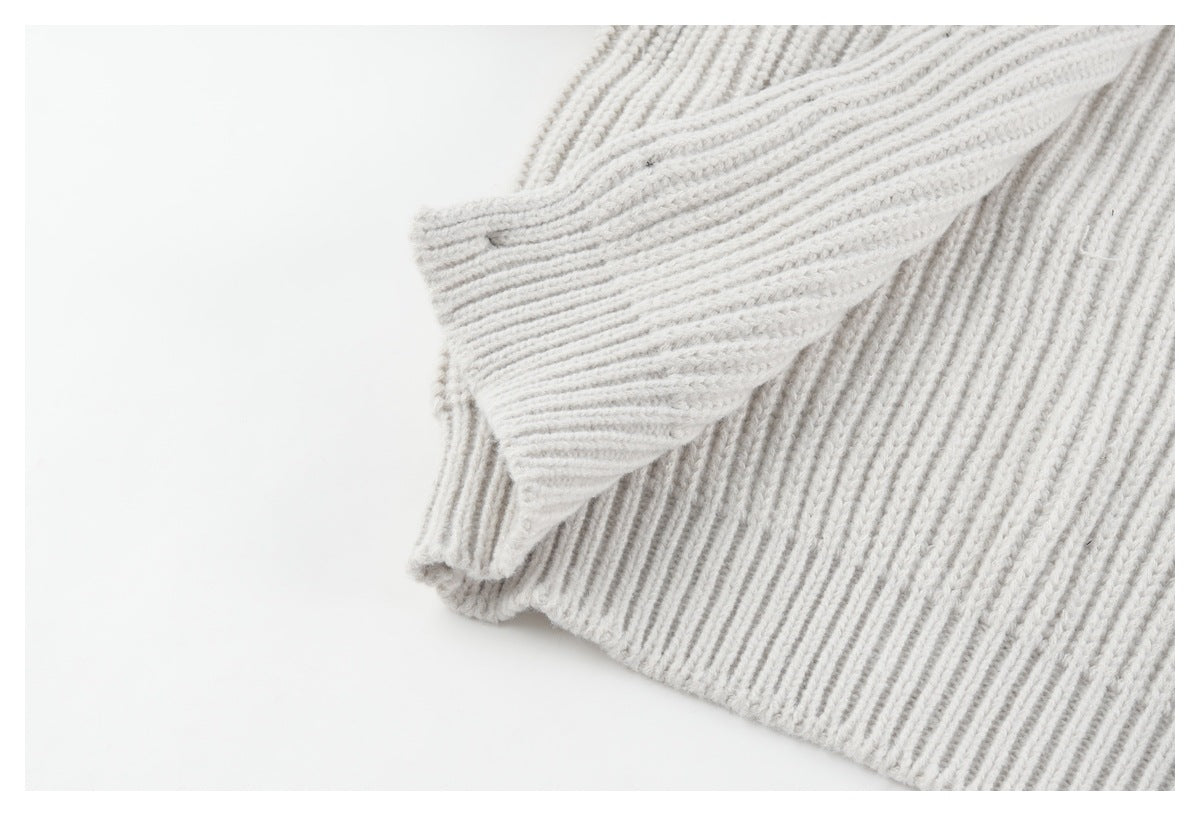 Close-up of the off-white sweater's ribbed knit and bottom hem.