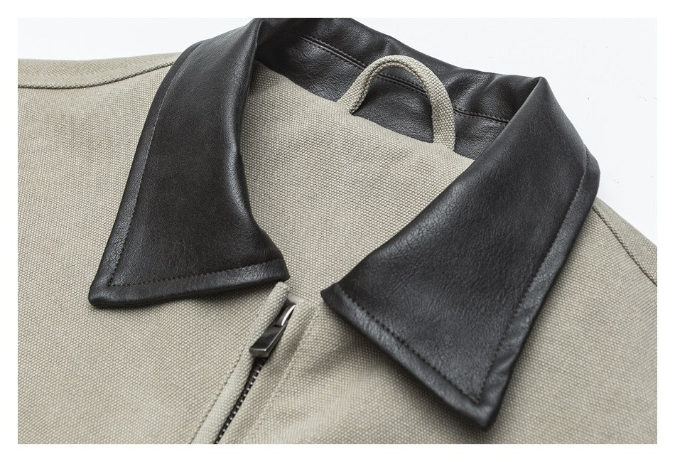Close-up of a beige jacket with a black leather-look collar, short zipper, and small loop behind the collar.
