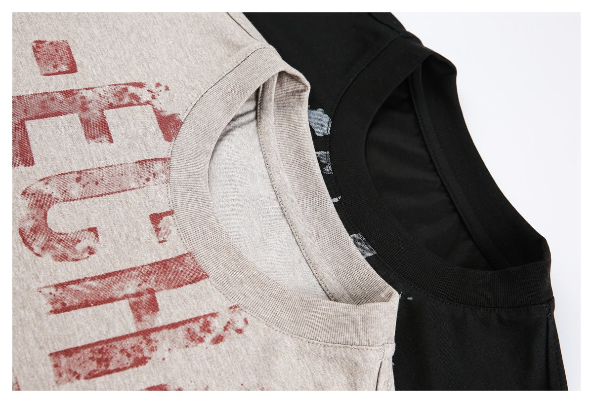 Close-up of beige and black T-shirts showing their ribbed crew necklines and distressed front prints.