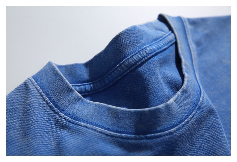 Close-up of the blue T-shirt's ribbed crew neckline and interior stitching.