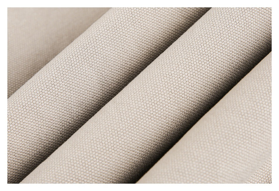 Close-up showing the woven texture of beige garment fabric in soft folds.
