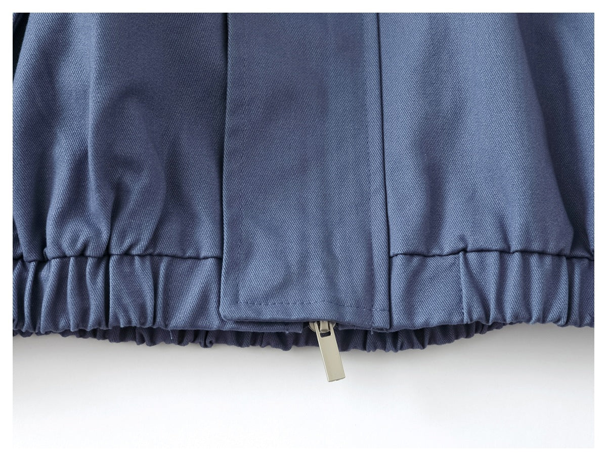 Close-up of the jacket’s gathered elastic hem and front zipper pull.