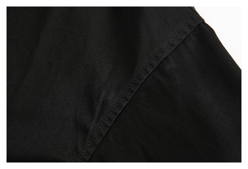 Close-up of a diagonal stitched seam on black garment fabric.