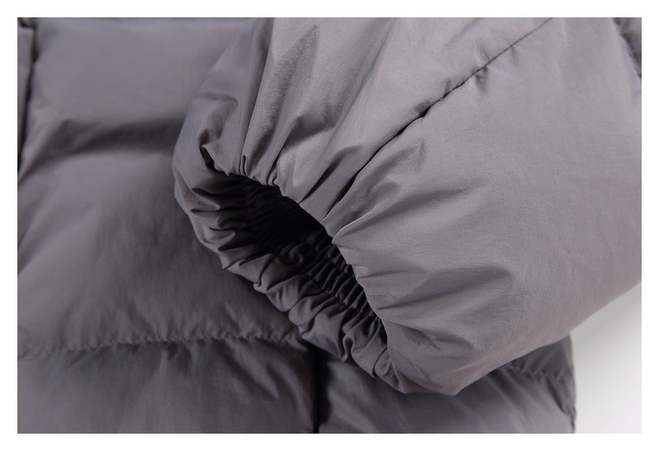 Close-up of the gathered elastic cuff on a gray puffer jacket sleeve.