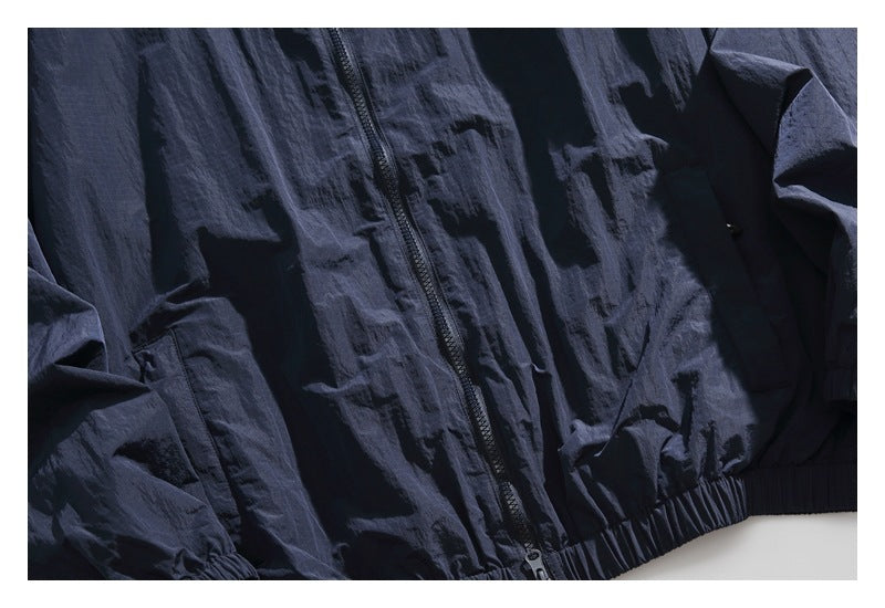 Close-up of the jacket's front zipper, lower pockets and gathered elastic hem.