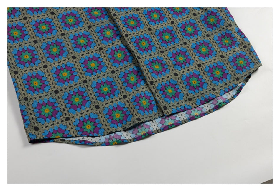 Close-up of the curved hem and printed fabric of a colorful button-up shirt.