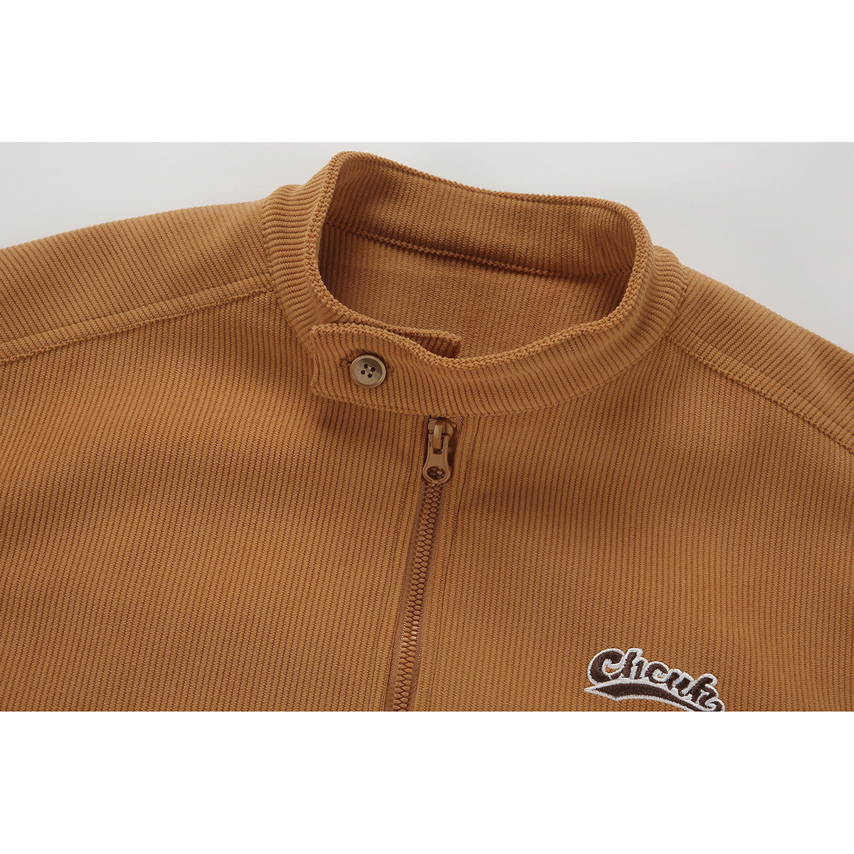 Close-up of a tan ribbed jacket collar with a button, front zipper, and embroidered chest logo.