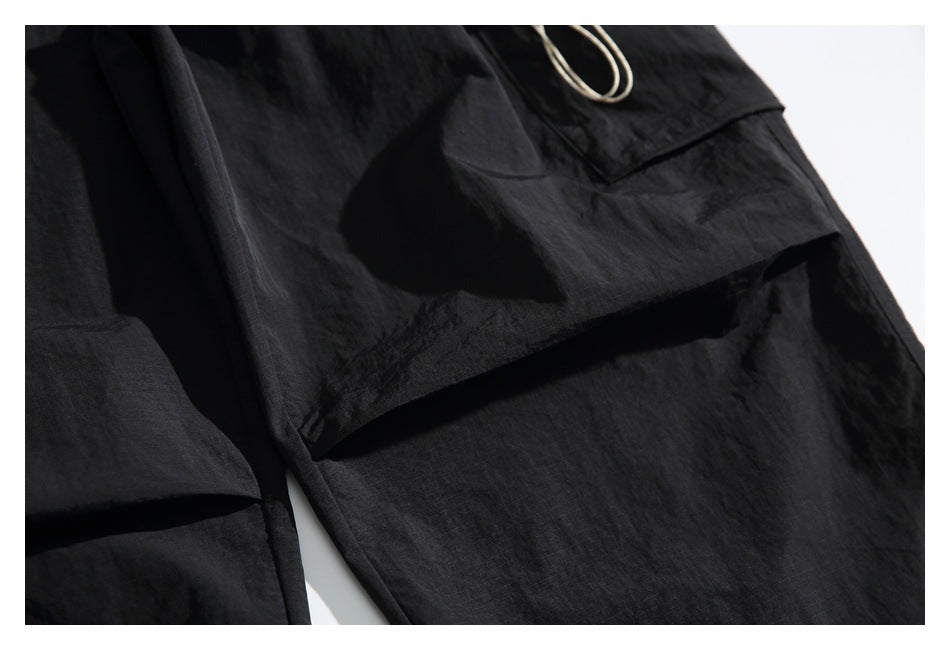 Close-up of a large pocket and stitched seams on black pants.