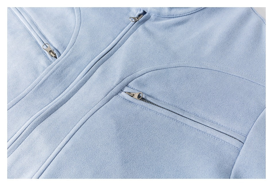 Close-up of a pale blue garment front showing the main zipper and a horizontal zippered chest pocket.