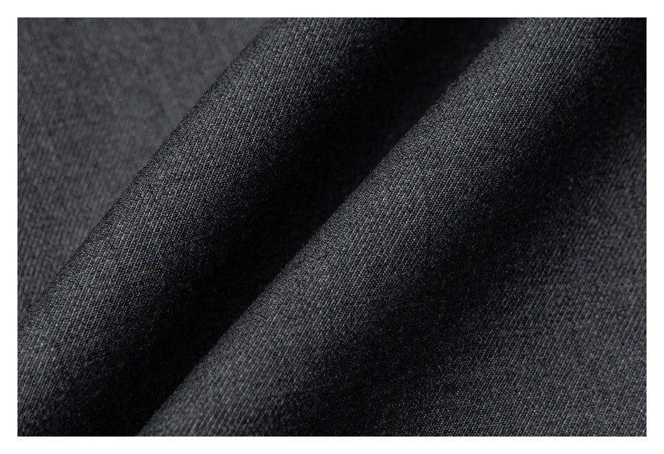 Close-up of dark charcoal fabric with a fine textured weave and a soft diagonal fold.