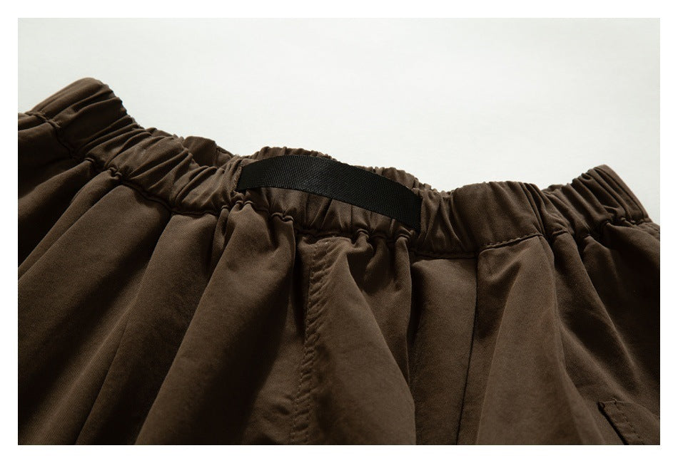 Close-up of the back of dark brown trousers showing the elastic waistband and a black belt loop.