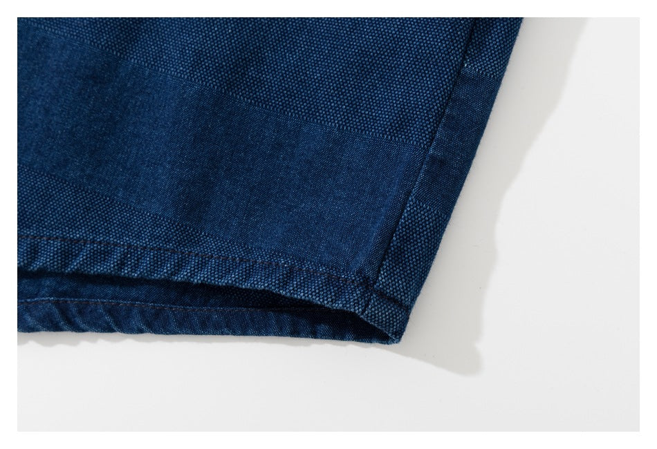 Close-up of the dark blue garment's stitched hem and textured fabric.