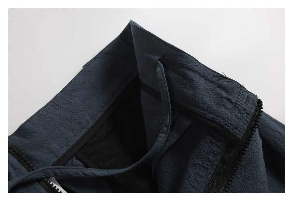 Interior close-up of blue-gray trousers showing the waistband lining and open zipper.