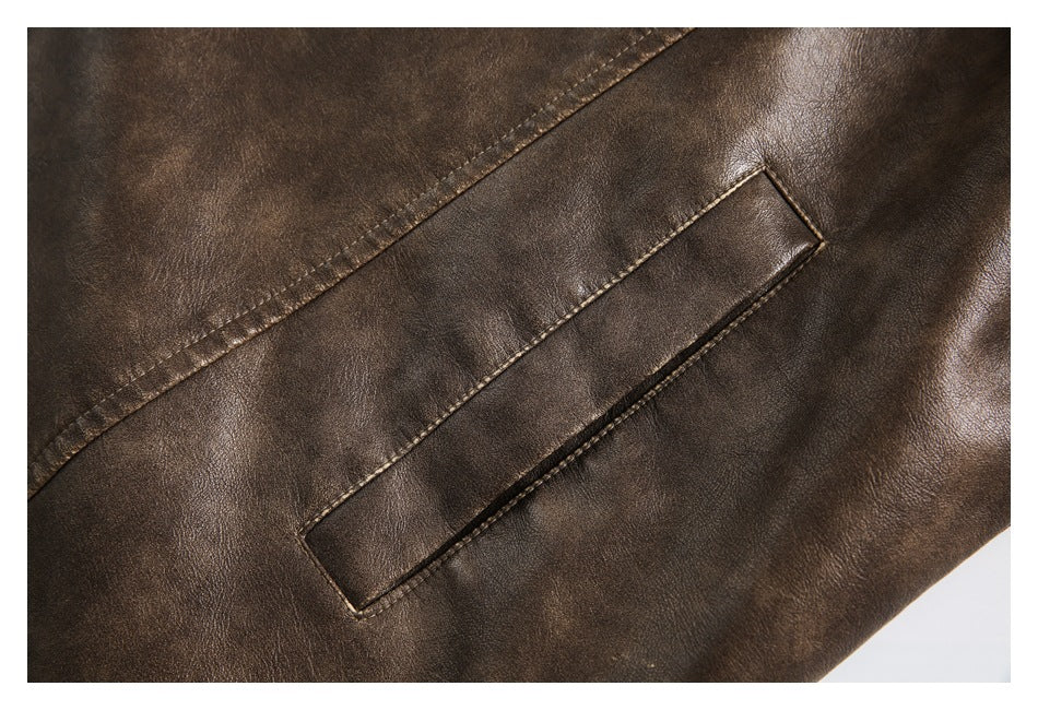 Close-up of a brown jacket's narrow welt pocket and surrounding stitched panels.