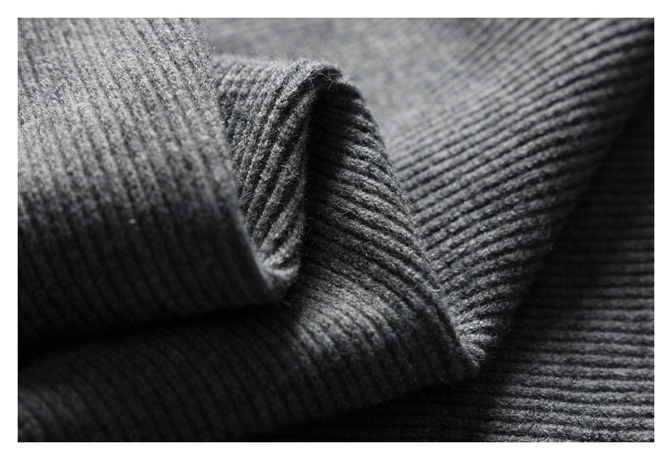 Close-up of folded charcoal gray rib-knit fabric showing its raised vertical texture.