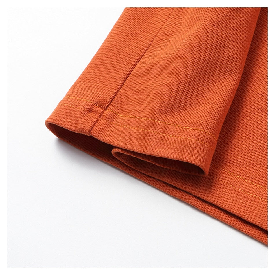Close-up of an orange sleeve cuff and stitched hem.