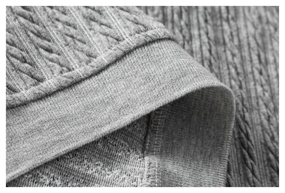 Close-up of a gray ribbed band folded back to show the knit underside and stitching.