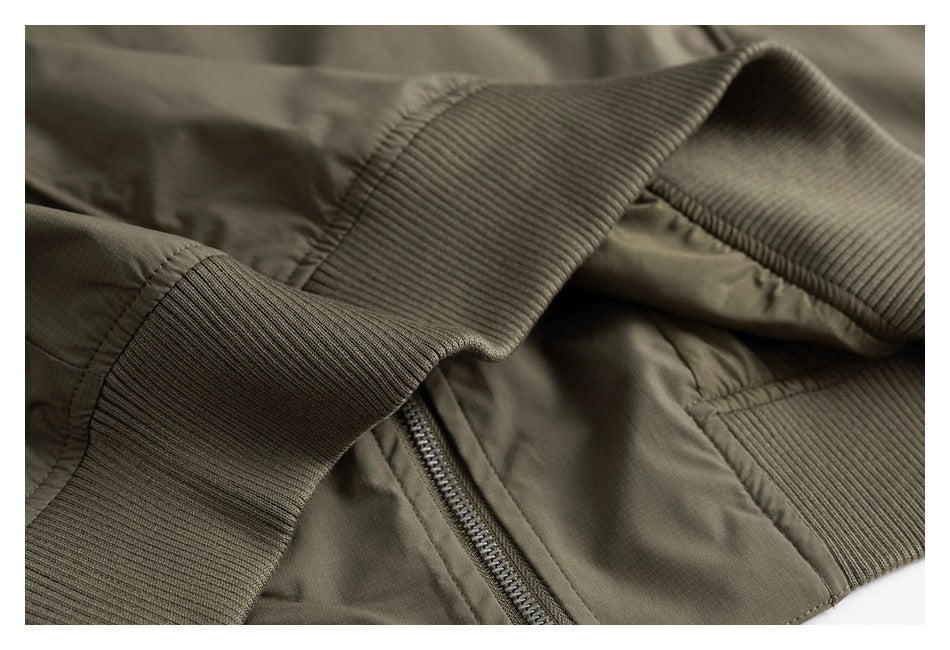Close-up of an olive-green garment with a ribbed cuff and zipper.