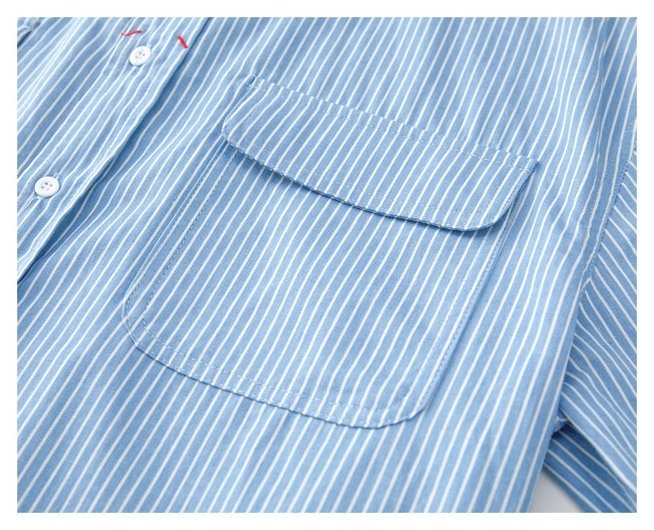 Close-up of a blue-and-white striped shirt showing its stitched chest pocket and white buttons.