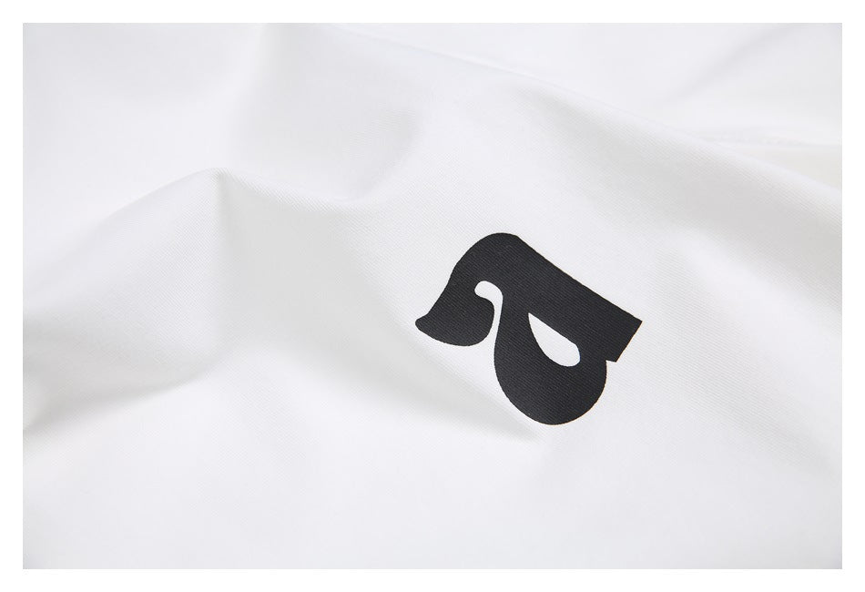 Close-up of a black abstract printed mark on white fabric.