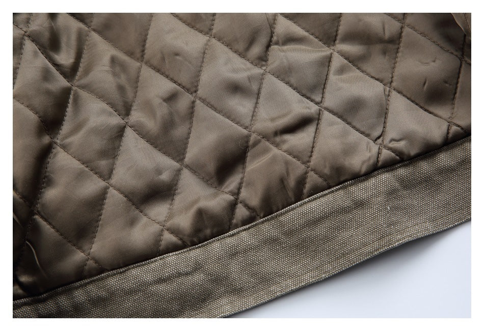 Close-up of taupe-brown diamond quilting and a wide, dark textured garment edge.