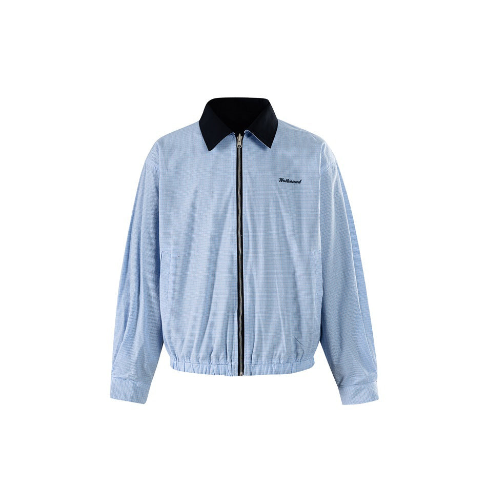 Front view of a light blue checked zip-up jacket with a black collar, cuffs, and hem; small embroidered chest text.
