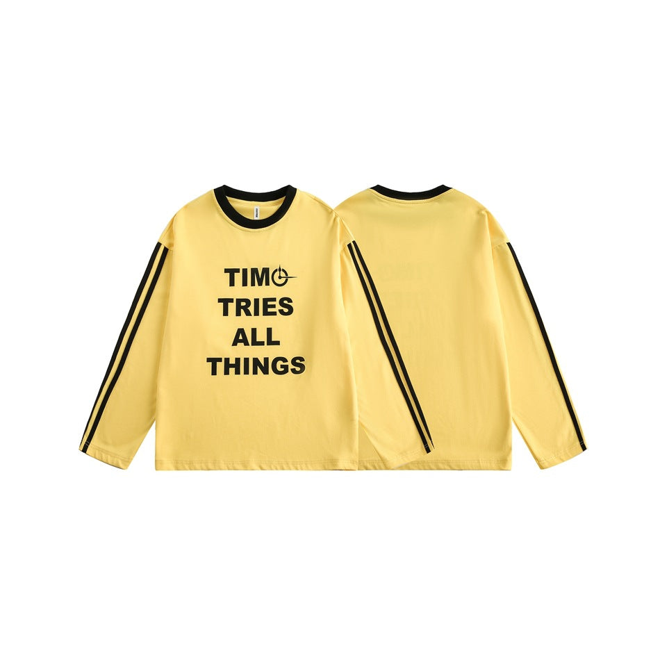 Yellow long-sleeve shirt shown front and back, with black collar trim, sleeve stripes, and a bold black chest slogan.