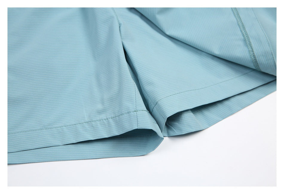Close-up of the light blue shorts' stitched hems and fine horizontal stripe texture.