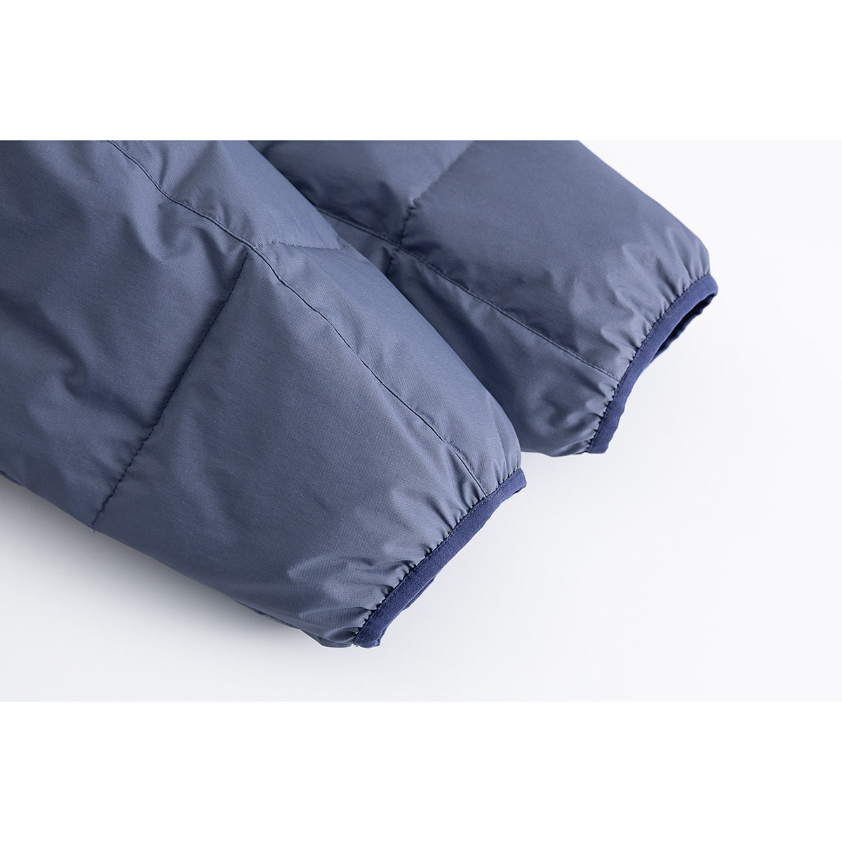 Close-up of the slate-blue jacket's padded sleeves and dark-trimmed cuffs.
