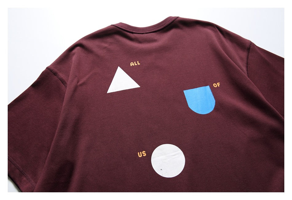 Back view of a burgundy short-sleeve shirt with white and blue geometric shapes and small yellow lettering.